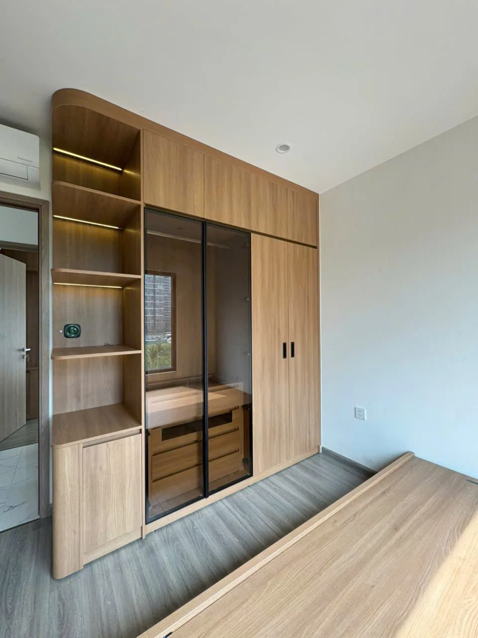 Hệ tủ áo vân gỗ kết hợp cánh kính và hộc mở — Căn hộ Vinhomes · Khu vực Quận 9 cũ